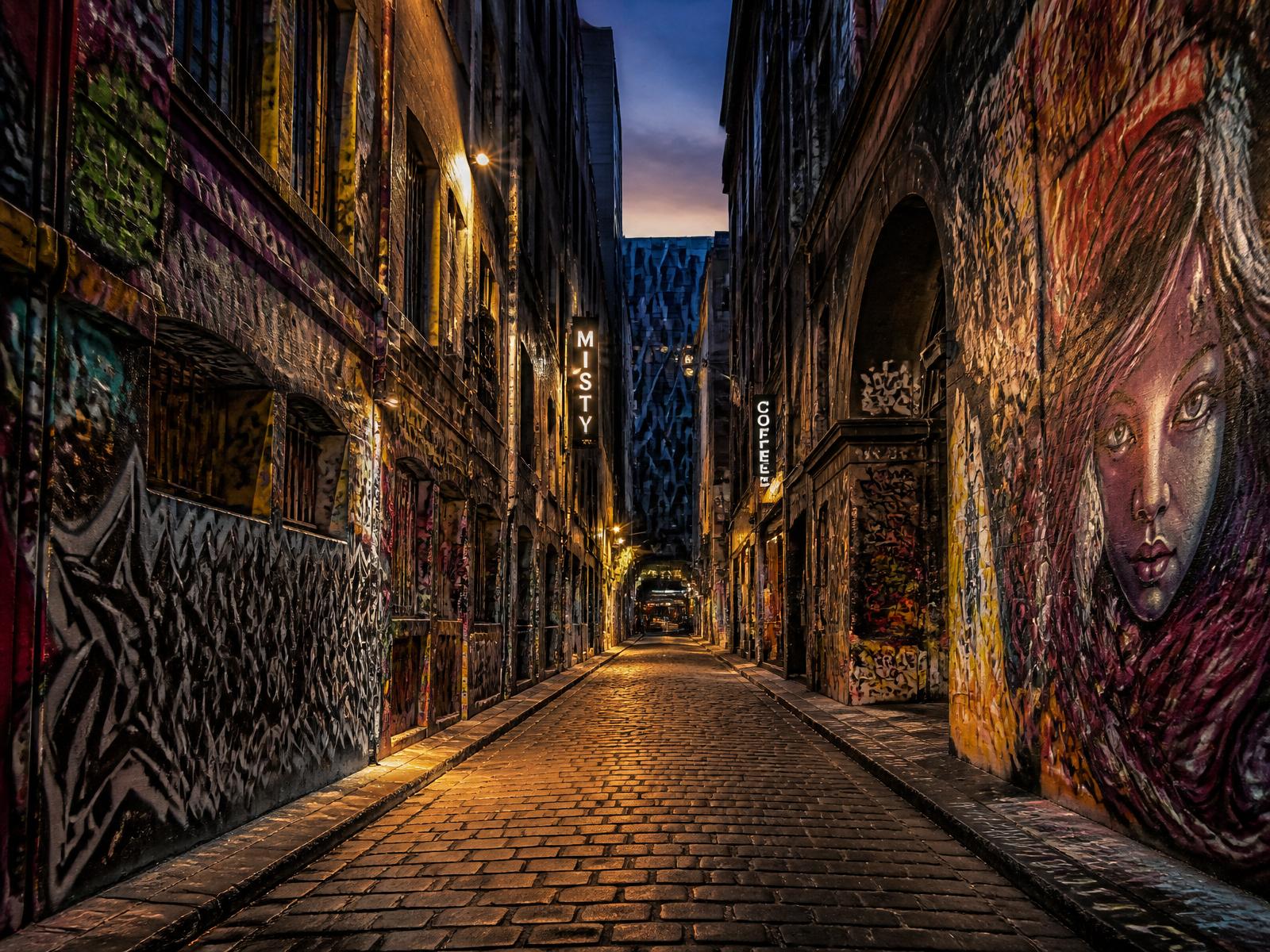 A Melbourne laneway at night, lit by shopfronts and string lights
