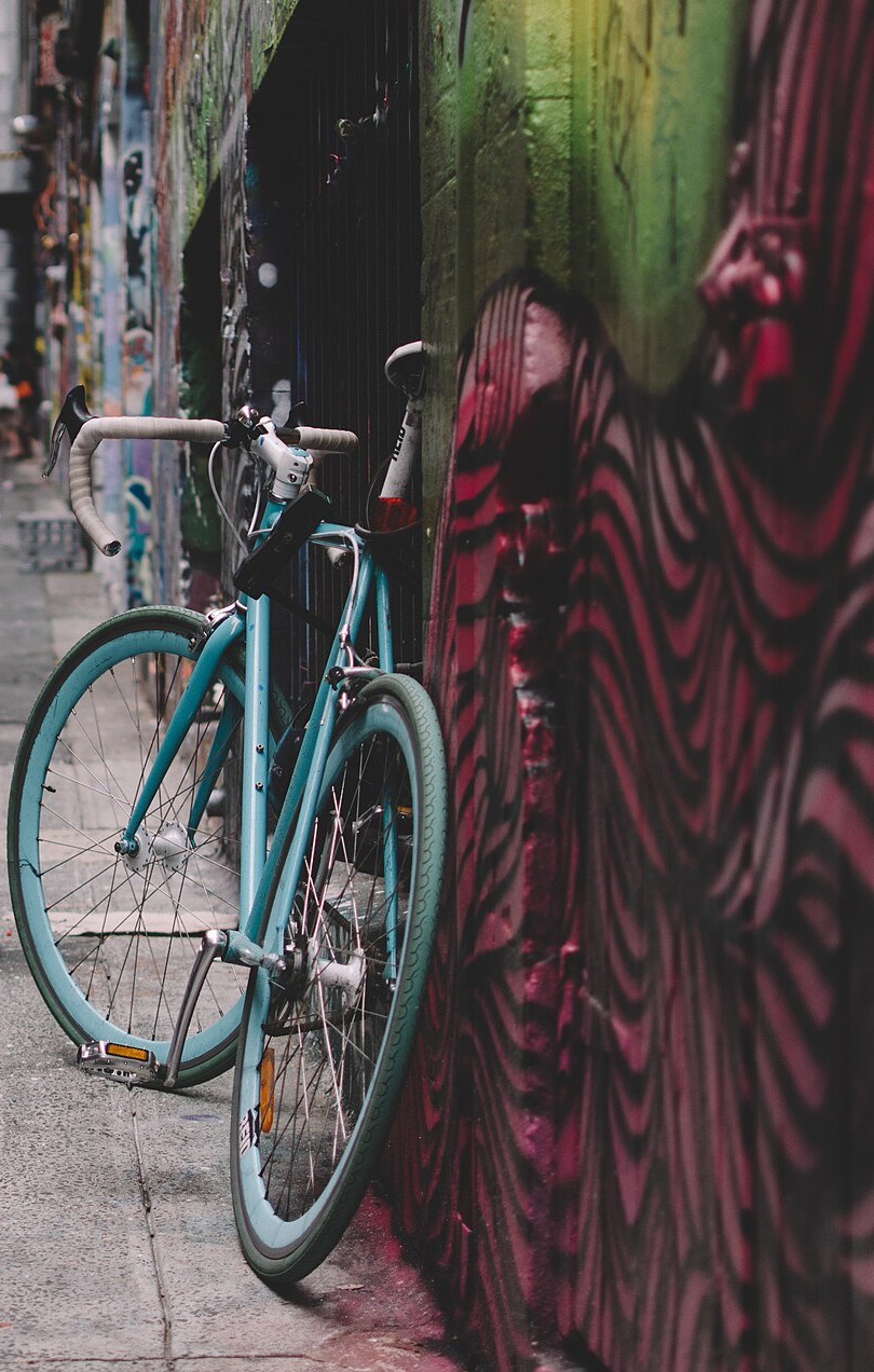 A bike leaning against a layered painted wall in a Melbourne laneway